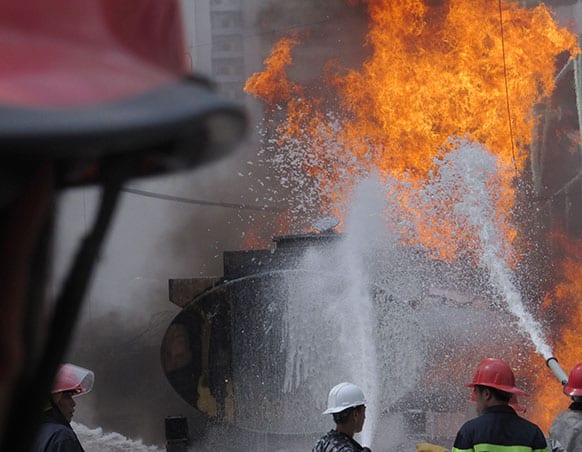Firefighters attempt to extinguish a gas tanker that caught fire in Hanoi, Vietnam. There were no reported injuries as a result of the fire, which apparently started from a car at the gas station.