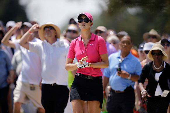 Michelle Wie holds her right wrist as she watches her shot from the rough on the 6th hole during the final round of the ShopRite LPGA Classic golf tournament in Galloway Township, N.J.