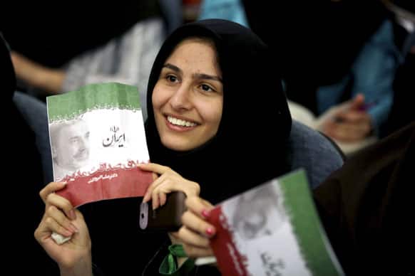 A supporter of Iranian presidential candidate, Ali Akbar Velayati, a conservative former Foreign Minister, holds up an electoral leaflet, during a campaign meeting, at the Beheshti University, in Tehran, Iran.