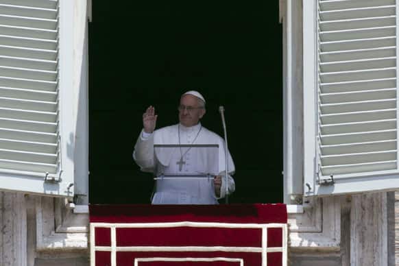 Pope Francis blesses the crowd during the Angelus noon prayer, from the window of his studio overlooking St. Peter`s Square, at the Vatican.