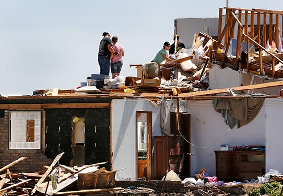 A man and woman comfort each other briefly as they join others in the search for items that can be saved in what remains of an upstairs bedroom in Kay and Bonnie Meritt`s home at 20545 SW 15 in Union City, Okla.