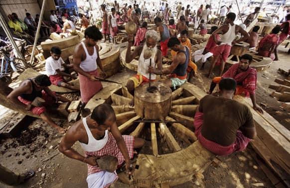Carpenters give final touches to wheels for wooden chariots of Lord Jagannath, Balabhadra and Subhadra for the forthcoming Rath Yatra, or Procession of Chariots, at Puri 65 kilometers away from the Bhubaneswar.