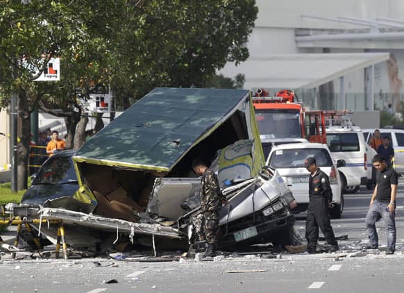 Investigators examine the scene of an overnight explosion that ripped through an apartment in a busy, upscale district of Taguig city, east of Manila, Philippines.