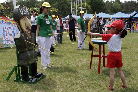 A North Korean girl fires an arrow at a target made to look like a US soldier as children play games to mark International Children`s Day at Mangyongdae Amusement Park on the outskirts of Pyongyang.