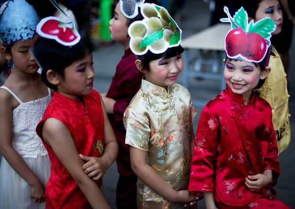 Children wearing costumes wait to participate in a stage show on International Children`s Day organized by the Chinese Foreign Affairs Office at Children`s Palace of Dongcheng district in Beijing.
