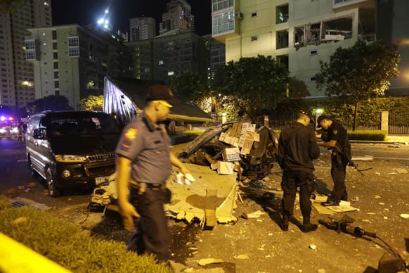 Police examine the scene after an explosion ripped through an apartment in the upscale district of Taguig city, east of Manila, Philippines.