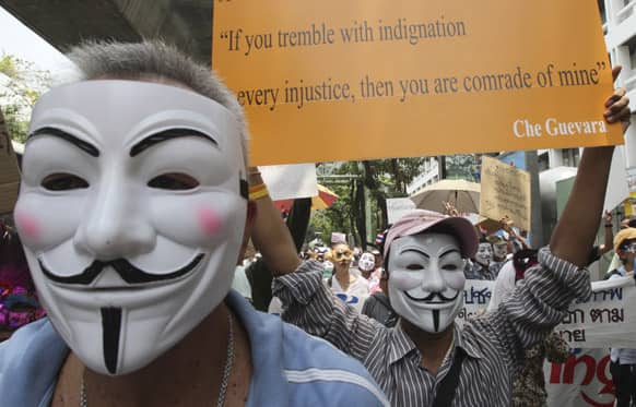 Masked Thai protesters holding placards and banners stage an anti-government rally in Bangkok, Thailand.