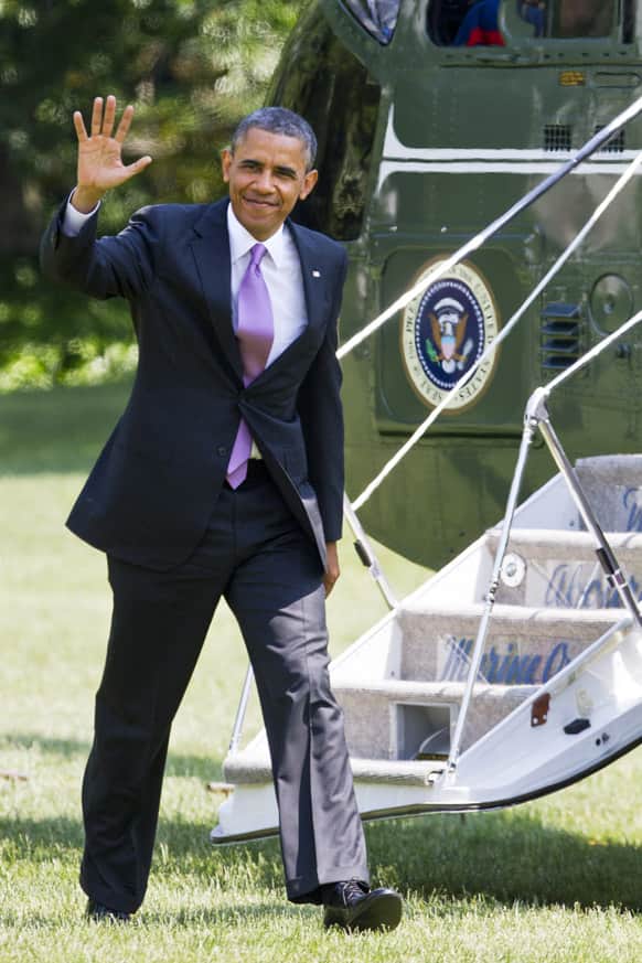 President Barack Obama waves to the media as he exits the Marine One helicopter and walks on the South Lawn of the White House in Washington.