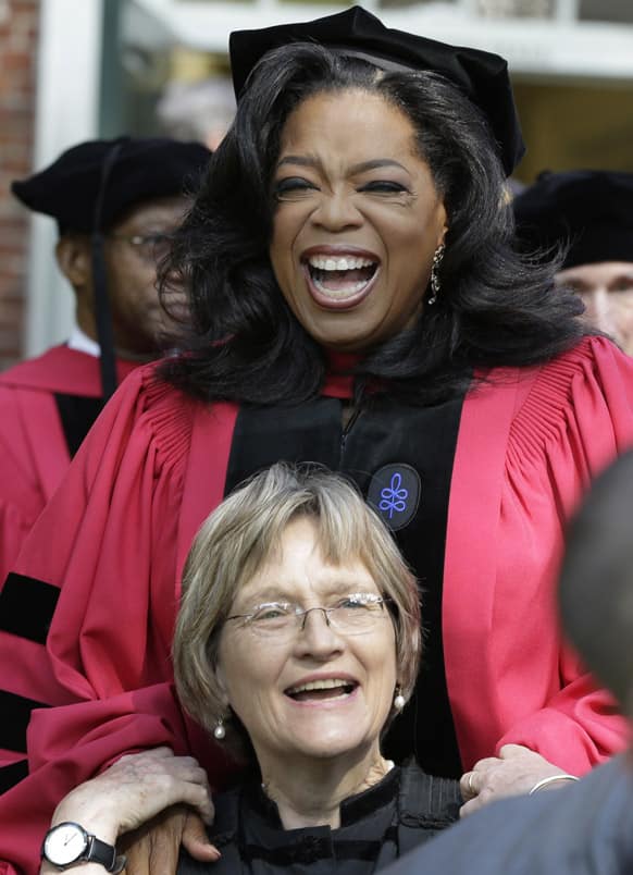 Oprah Winfrey laughs with Harvard University President Drew Faust prior to receiving an honorary degree from Harvard during commencement ceremonies in Cambridge, Mass.