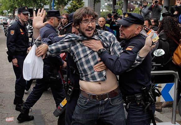 Police arrest a protestor after he distributes flyers during a demonstration outside a bad bank (SAREB) in Madrid, Spain.