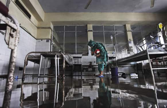 An attendant of a patient looks for her belongings in a ward filled with water after patients were evacuated following a small fire at the Guru Teg Bahadur hospital in New Delhi.
