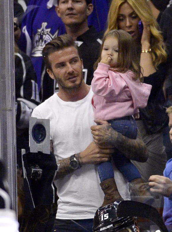 Retired soccer player David Beckham holds his daughter Harper as he watches the Los Angeles Kings play the San Jose Sharks in Game 7 of the Western Conference semifinals in the NHL hockey Stanley Cup playoffs, in Los Angeles.