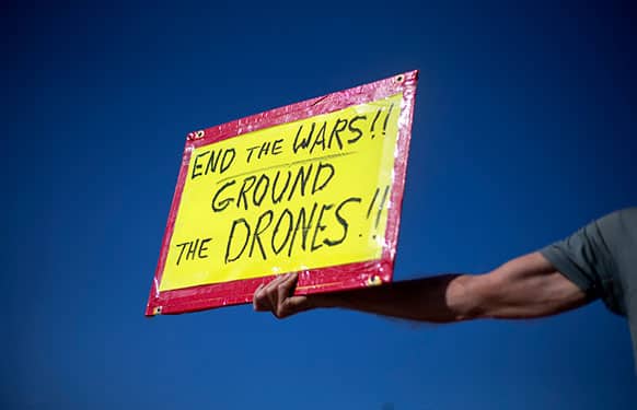 Tom Coffia, of Atlanta, holds a sign out for passing motorists as he takes part in a demonstration protesting against the use of drones outside the International Conference on Unmanned Aircraft Systems at the Grand Hyatt Hotel, in Atlanta.