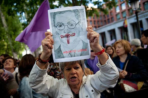 A demonstrator hold a banner depicting Spain`s Justice Minister Alberto Ruiz-Gallardon and reading `Free abortion` during a protest against the government`s proposed new abortion law outside the Health Ministry headquarters, in Madrid.