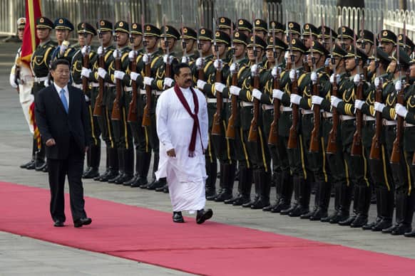 Chinese President Xi Jinping walks with Sri Lankan President Mahinda Rajapaksa during a welcome ceremony at the Great Hall of the People in Beijing, China.