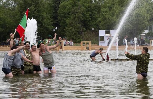 Russian border guard veterans, holding a Russian Border guard flag, pose for a photo while bathing in a fountain in Moscow`s Gorky Park as they celebrate the Border Guard`s Day in Moscow.