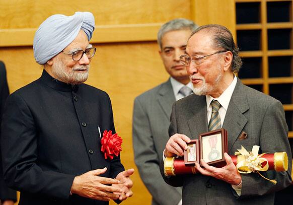 PM Manmohan Singh, left, smiles as he presents