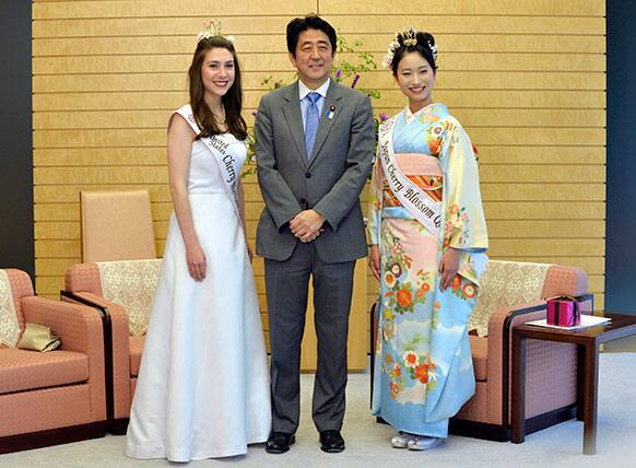 Japanese Prime Minister Shinzo Abe, center, poses with US Cherry Blossom Queen Mary Anne Morgan, left, from Oklahoma and Japan`s Cherry Blossom Queen Chiori Kobayashi, right, during a courtesy call on the prime minister at the latter`s official residence in Tokyo, Japan.
