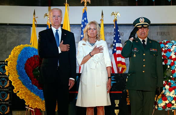 Vice President Joe Biden, left, his wife, Dr. Jill Biden, center, and Colombia`s Commander of the Armed Forces Alejandro Navas, stand for the Colombian national anthem during a ceremony to honor Air Force servicemen fallen on the line of duty in a chapel at the Air Force base in Bogota, Colombia.