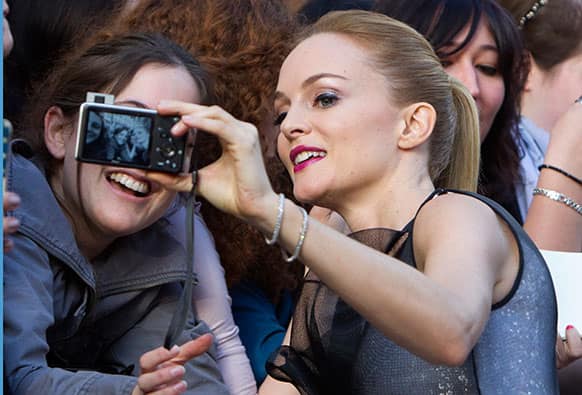 Actress Heather Graham poses for a photo with a fan as she arrives for the French premiere of his film The Hangover Part III at the UGC Normandie Champs Elysee in Paris.