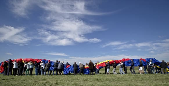 Romanians carry a huge national flag on the Clinceni Airfield, south of Bucharest, Romania. Romania entered the Guinness Book of records after it unveiled the largest flag ever made.