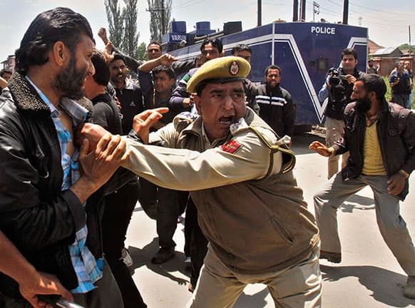 An Indian policeman detains a Kashmiri government employee during a protest in Srinagar. Police detained dozens of government employees during the protest demanding regularization of contractual jobs and a hike in salary.