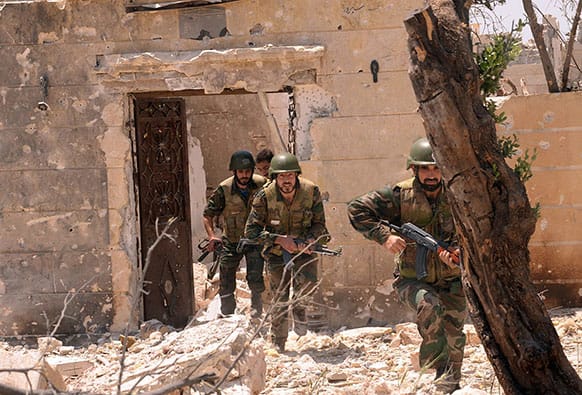 Syrian forces loyal to Syrian President Bashar Assad run to take their position during clashes against Syrian rebels, in Aleppo, Syria. Syria`s Information Ministry says rebels have killed a TV correspondent who was covering clashes near the border with Lebanon.