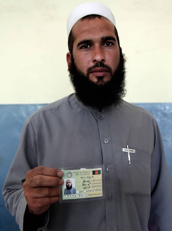 An Afghan resident shows his identification card at a voter registration center in Jalalabad east of Kabul.
