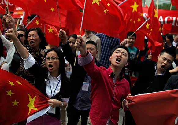 Protests wave Chinese flags as they protest against what they consider a Spanish media defamation campaign against the Chinese community in Madrid.