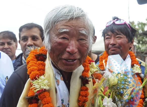 80-year-old Japanese climber Yuichiro Miura, who became the oldest conqueror of Mount Everest on Thursday, is garlanded as he returns from camp 2 by helicopter in Katmandu.