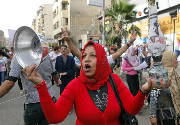 An Egyptian woman holds an empty pot with Arabic reading,