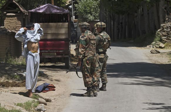 Indian army soldiers order a Kashmiri civilian to lift his shirt to reveal his body during a gunbattle in Buchoo Balla, about 40 kilometers (25 miles) south of Srinagar.