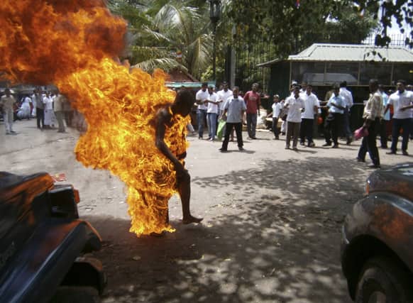 A Sri Lankan Buddhist monk identified as Bowatte Indrarathane walks after self immolating outside the sacred Temple of the Tooth in Kandy, Sri Lanka. Indrarathane allegedly set himself on fire during a protest demanding an end to cattle slaughter, according to Press Trust of India.