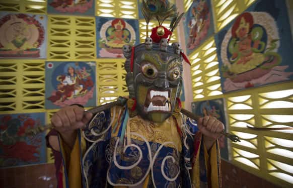 A monk wearing magnificent costume and mask performs during a procession on Wesak day in Ipoh, Malaysia.
