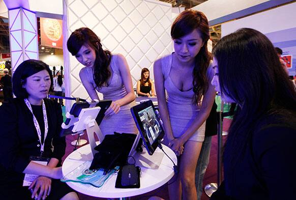 Attendants, middle, chat with visitors over online baccarat game during the Global Gaming Expo Asia in Macau.