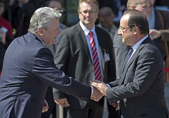 German President Joachim Gauck, left, shakes hands with French President Francois Hollande, right, in Leipzig, Germany.