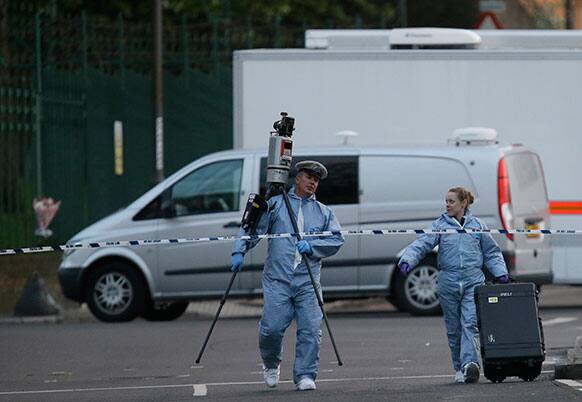 Police and forensic officers work near the scene of an attack which has left one man confirmed dead and two people wounded near Woolwich barracks in London.