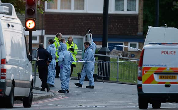 Police and forensic officers near the scene of an attack which has left one man confirmed dead and two people wounded near Woolwich barracks in London.