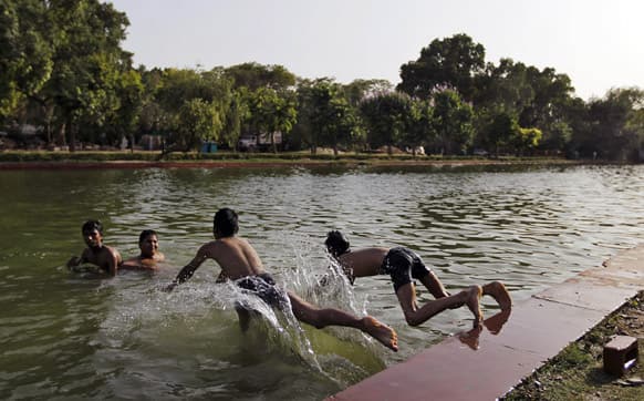 Boys cool off in a body of water on a hot afternoon in New Delhi. The capital city has been reeling under a heat wave with temperature hitting 44 degree Celsius.