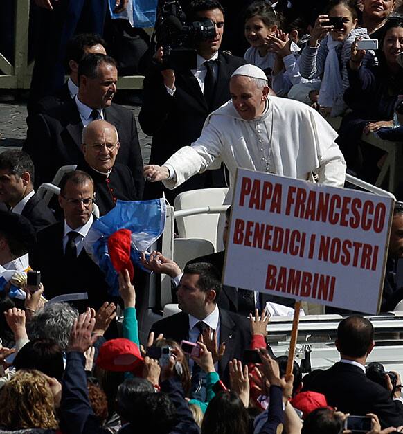 An Argentinian flag is thrown by a faithful to Pope Francis as he arrives for his weekly general audience in St. Peter`s Square at the Vatican.