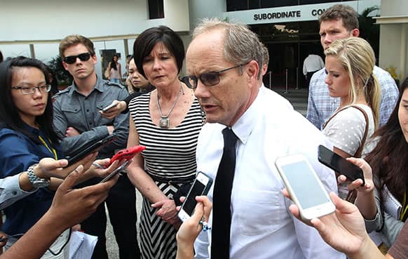 The parents of late American software engineer Shane Truman Todd, Mary, center left, and Rick Todd, right, with their son Dylann, second left, watching as they speak to reporters after leaving the Subordinate Courts of Singapore.