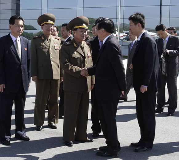 High-ranking North Korean party and military official Choe Ryong Hae, center left, shakes hands with Chinese Ambassador Liu Hongcai as Choe departs for China as a special envoy of North Korean leader Kim Jong Un, at Pyongyang airport, North Korea.