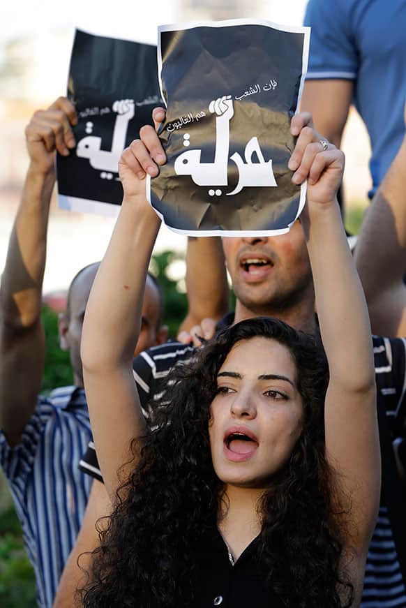 A Syrian activist shouts anti-Hezbollah slogans, as she holds up a placard in which they replaced Hezbollah’s logo with the word “freedom,” during a protest against the participation of Hezbollah members in the fighting in the Syrian town of Qusair.
