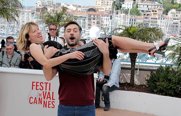 Actor Filippo Timi carries director Valeria Bruni Tedeschi as they pose during a photo call for the film Un Chateau en Italie at the 66th international film festival, in Cannes.