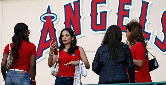 Mrs. Globe 2013, Sheryl Ann Baas, second from left, of Holland, takes a photo of Ivy Heward-Mills of Ghana, a competitor for the October competition, as they arrive at at Angel Stadium to see their first baseball game between the Seattle Mariners and Los Angeles Angels in Anaheim.