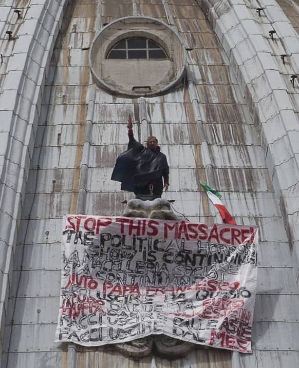 Italian businessman Marcello di Finizio stands by his banner with writings against the Italian Government and the Euro as he protests on St. Peter`s 130-meter-high (42-feet-high) dome, at the Vatican.