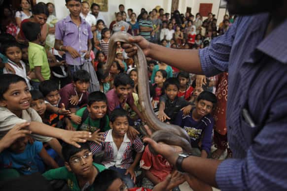 A member of Friends of Snakes Society displays a snake for children on the eve of International Biodiversity day in Hyderabad.