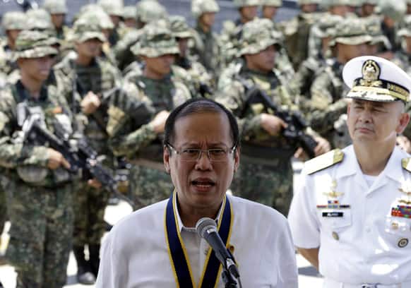 With Philippine Marines in the background, Philippine President Benigno Aquino III addresses the media shortly after leading the 115th Philippine Navy anniversary celebration at Fort San Felipe, Cavite city, southwest of Manila.