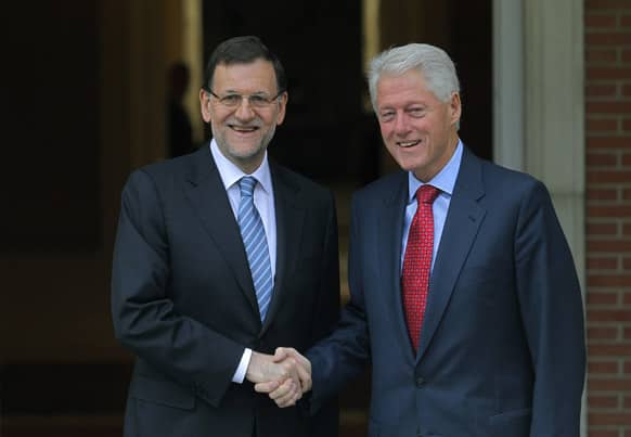 Spain`s Prime Minister Mariano Rajoy, shakes hands with former US President Bill Clinton during a meeting at the Moncloa Palace, in Madrid.
