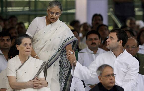 Congress party leader Rahul Gandhi, holds the hand of Delhi Chief Minister Sheila Dixit at a prayer meeting to mark the death anniversary of his father and former Indian Prime Minister Rajiv Gandhi at his memorial in New Delhi.